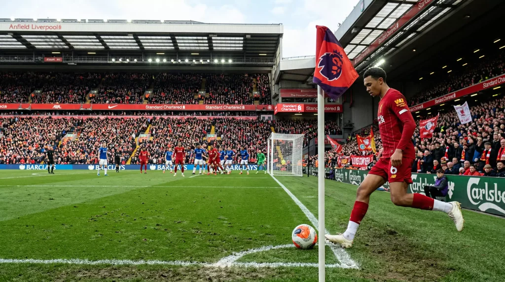 Jugador de fútbol ejecutando un saque de esquina en un estadio de la Premier League con banderín de córner