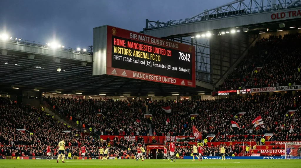 Marcador electrónico de estadio de fútbol mostrando resultado 2-1 en un partido de la Premier League